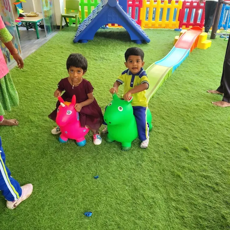Children playing on bouncy toys in the play area at Cherubs, Kondapur